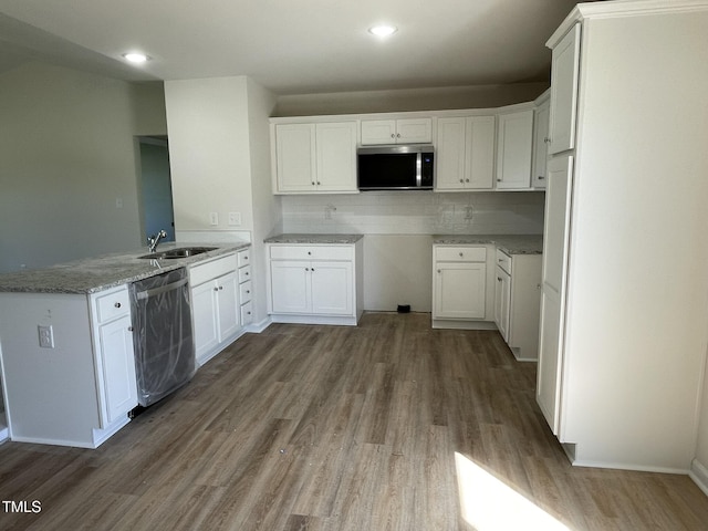 108 Pate Landing Dr, Selma, NC 27576 - kitchen with a peninsula, wood finished floors, light stone counters, a sink, and stainless steel appliances