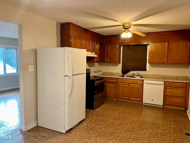 kitchen featuring white appliances, sink, ceiling fan, and a textured ceiling