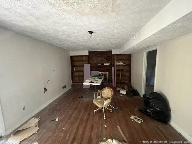 misc room featuring a textured ceiling and dark hardwood / wood-style floors