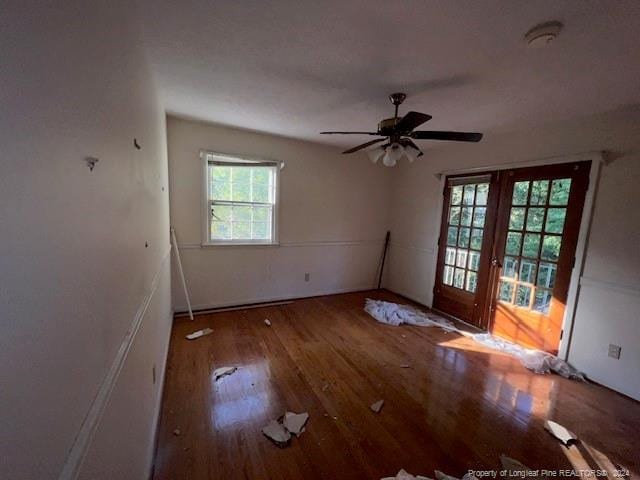 empty room with french doors, ceiling fan, and hardwood / wood-style flooring