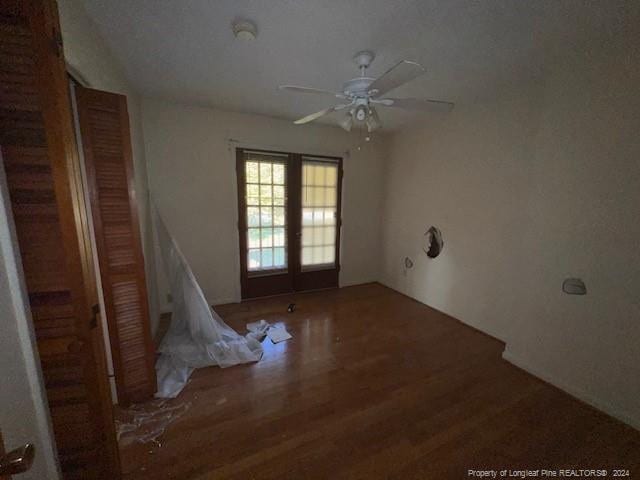 unfurnished room with french doors, ceiling fan, and dark hardwood / wood-style flooring