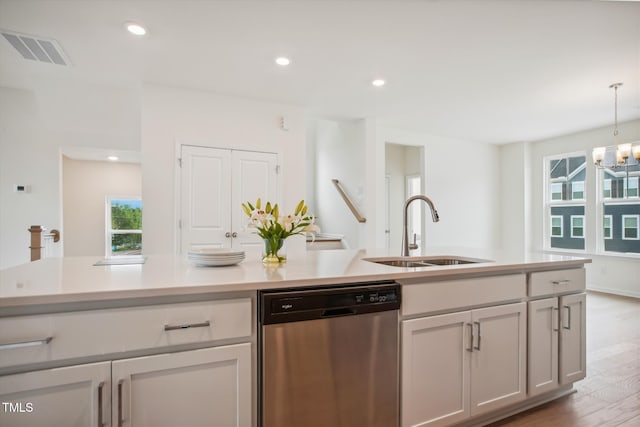 kitchen featuring sink, wood-type flooring, dishwasher, a wealth of natural light, and pendant lighting