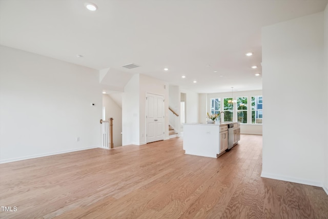 unfurnished living room featuring sink and light hardwood / wood-style flooring