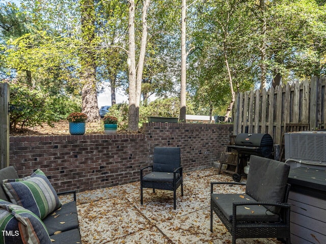 view of patio featuring area for grilling, fence, and central air condition unit