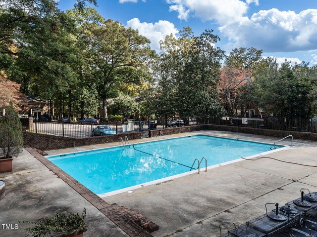 community pool featuring fence and a patio area