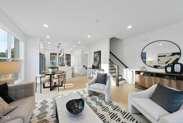 living room with a notable chandelier and light hardwood / wood-style floors