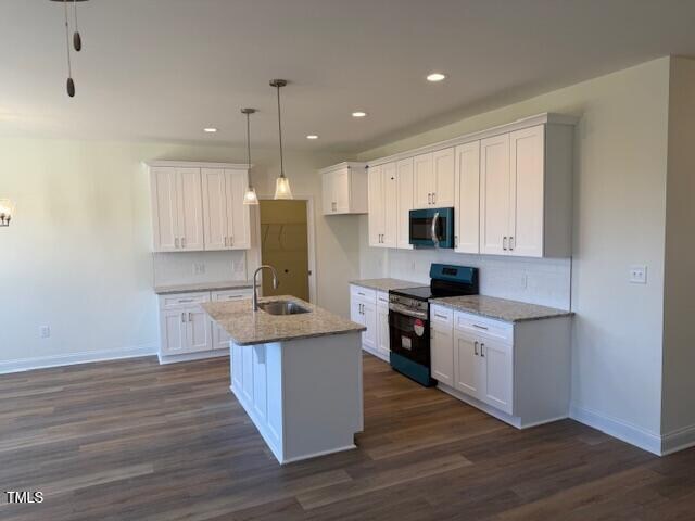 kitchen featuring white cabinetry, a kitchen island with sink, black appliances, and sink