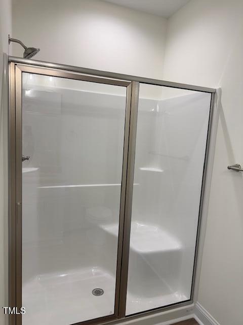 bathroom with a shower with door