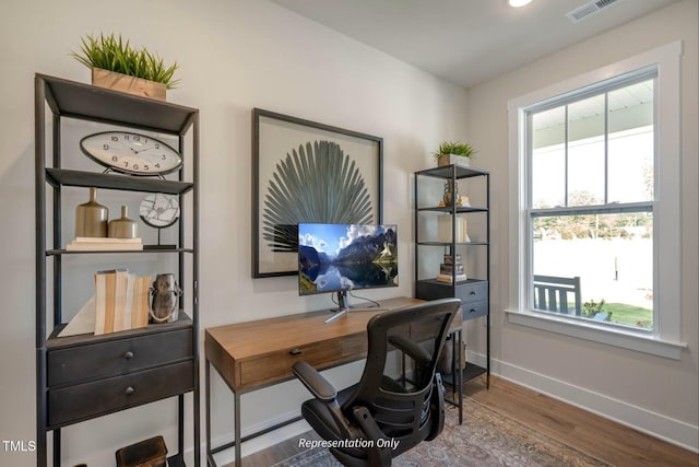 office space featuring baseboards, wood finished floors, and visible vents