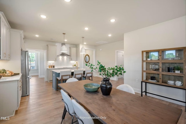 dining room featuring recessed lighting, baseboards, and light wood finished floors
