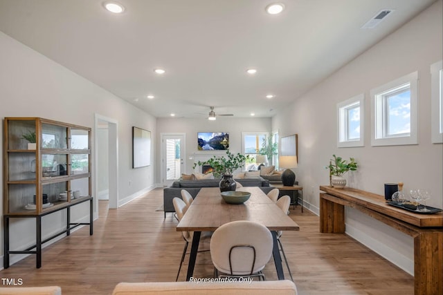 dining space featuring baseboards, a wealth of natural light, a ceiling fan, and visible vents