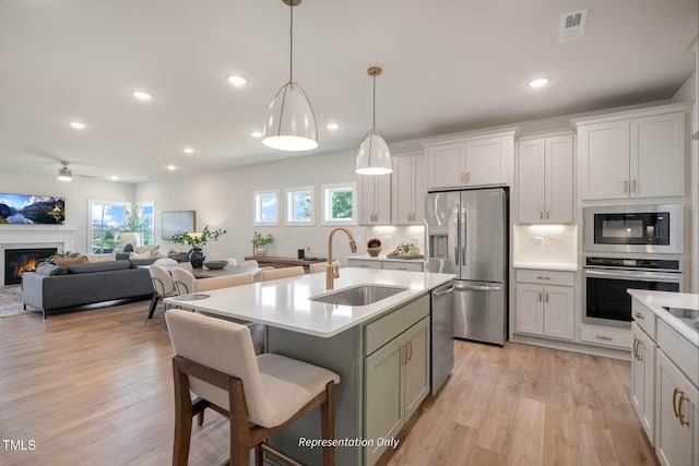 kitchen with light wood-style floors, a sink, recessed lighting, and stainless steel appliances