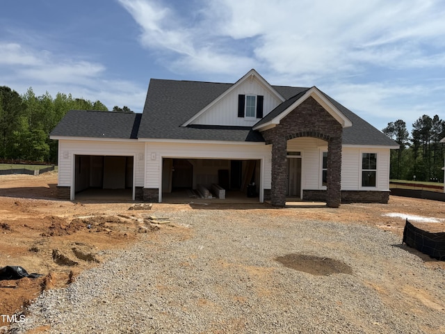 view of front of house with a garage, driveway, and roof with shingles