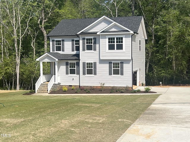 colonial-style house with driveway, a shingled roof, a front yard, and crawl space