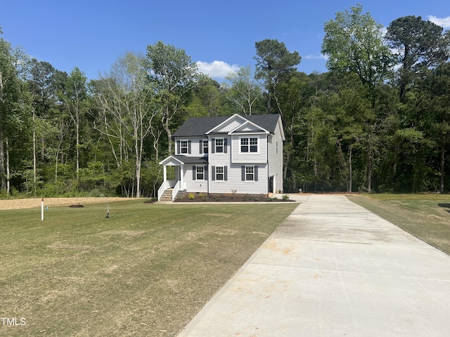 colonial-style house with crawl space, a view of trees, a front lawn, and concrete driveway