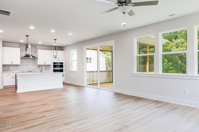 240 Fast Pitch Ln, Four Oaks, NC 27524 - unfurnished living room featuring light wood-type flooring, baseboards, recessed lighting, a ceiling fan, and a sink