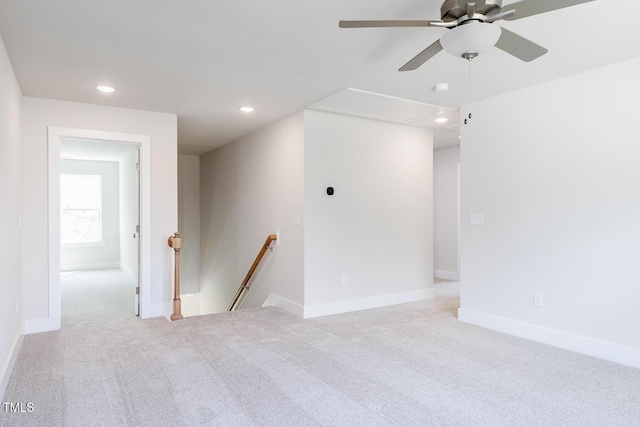 carpeted spare room with attic access, recessed lighting, ceiling fan, and baseboards