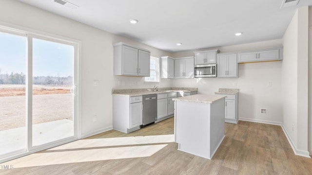 kitchen featuring a kitchen island, sink, gray cabinetry, light hardwood / wood-style floors, and stainless steel appliances