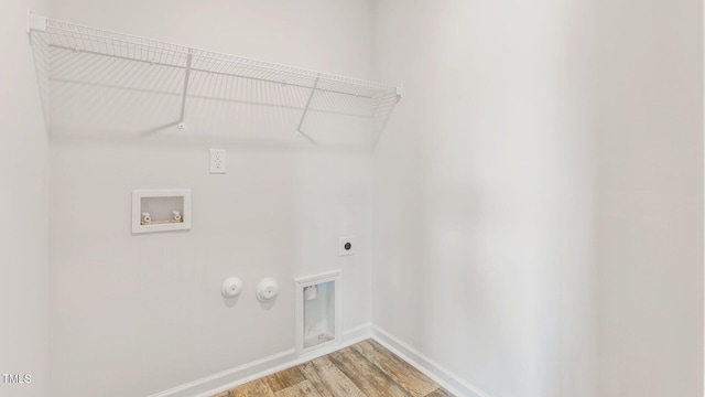 clothes washing area with hookup for a gas dryer, hookup for an electric dryer, hardwood / wood-style flooring, and washer hookup