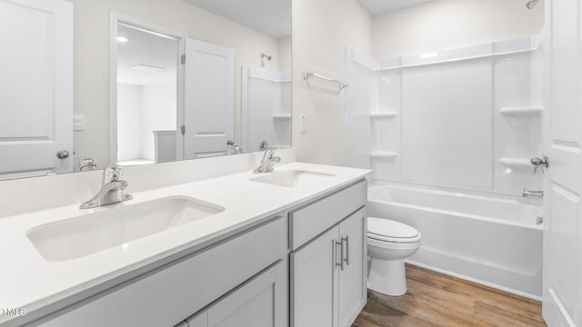 full bathroom with toilet, shower / bathing tub combination, hardwood / wood-style flooring, and vanity