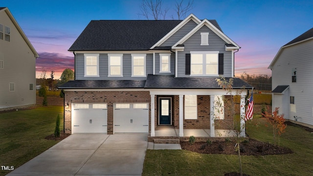 view of front of house with a lawn, a porch, and a garage