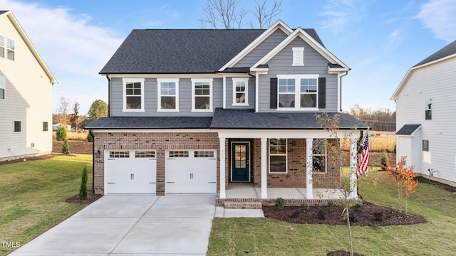 view of front of property featuring a garage, covered porch, and a front lawn