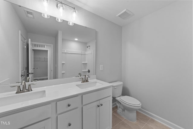 bathroom featuring tile patterned flooring, vanity, toilet, and walk in shower