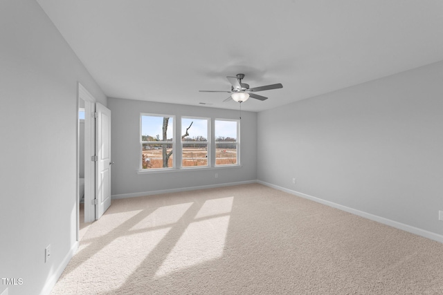 carpeted spare room with ceiling fan