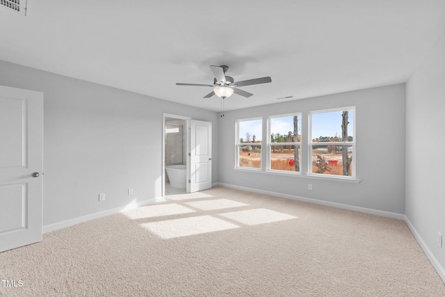 unfurnished bedroom featuring light carpet, connected bathroom, and ceiling fan