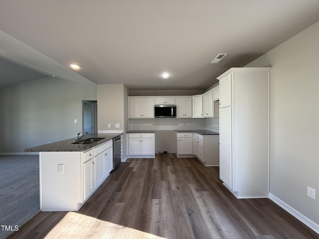 kitchen featuring white cabinetry, a sink, stainless steel appliances, and dark countertops