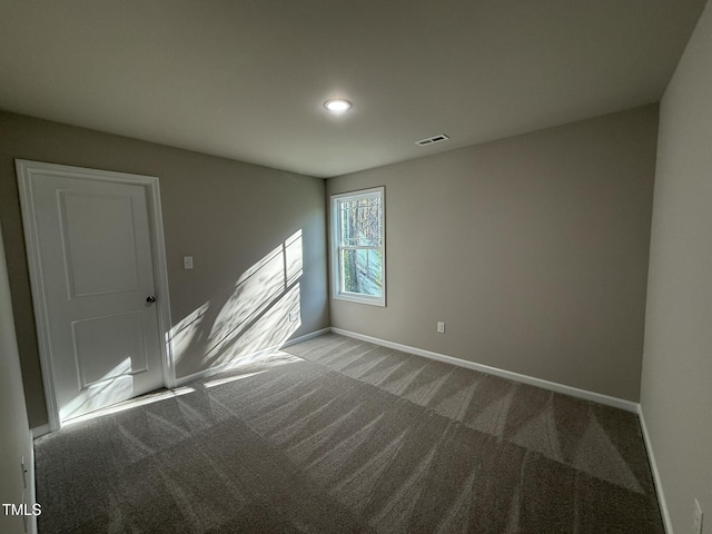 unfurnished room featuring baseboards, carpet floors, and visible vents