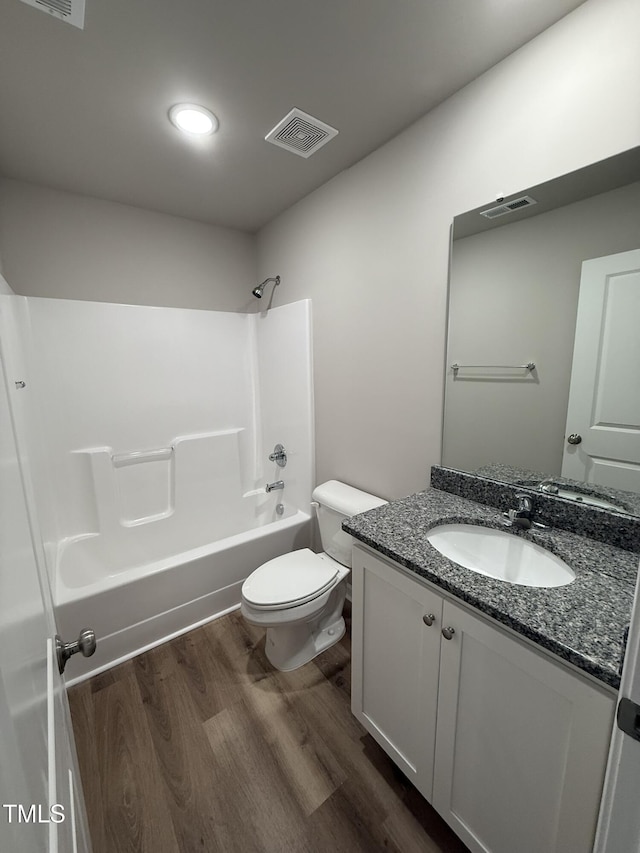 bathroom featuring visible vents, wood finished floors, toilet, and bathing tub / shower combination