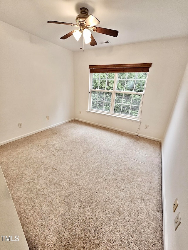 carpeted spare room featuring ceiling fan