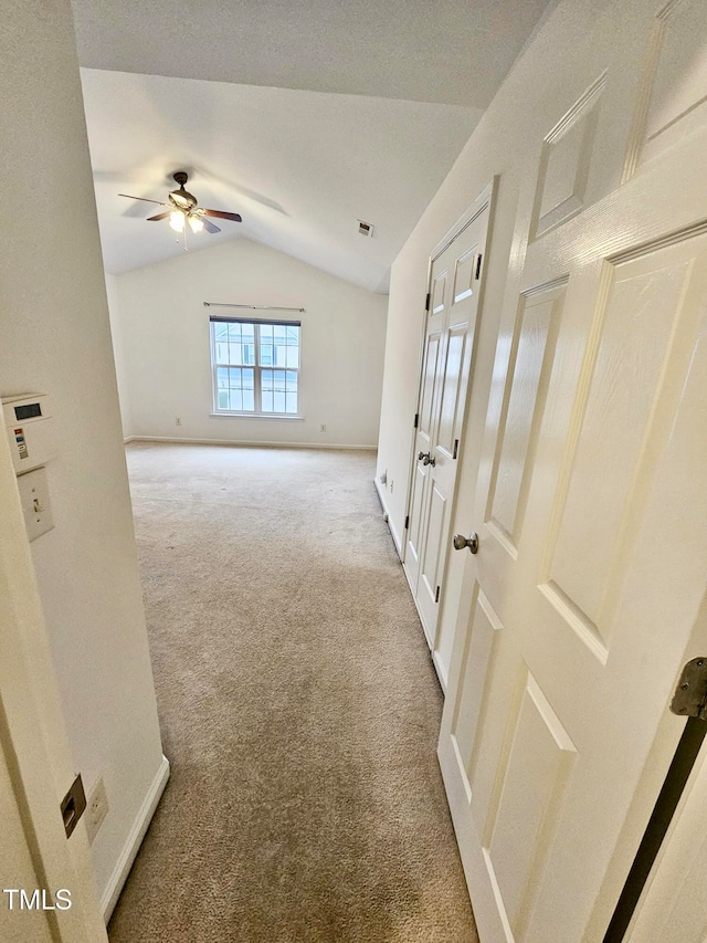 hall with light colored carpet and vaulted ceiling