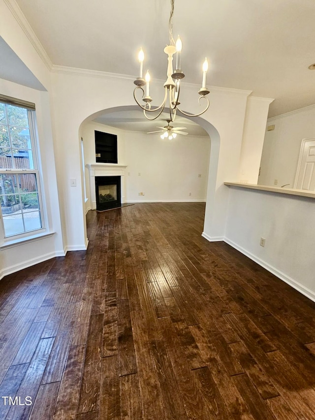 unfurnished living room featuring dark hardwood / wood-style floors, ornamental molding, and ceiling fan with notable chandelier