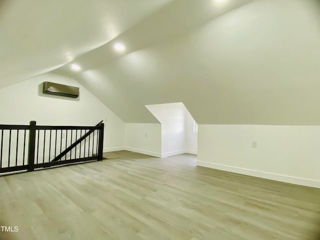 additional living space with light hardwood / wood-style floors and lofted ceiling