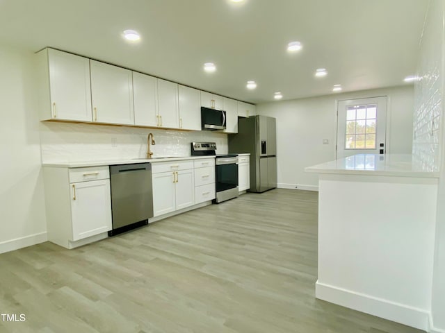 kitchen featuring white cabinetry, light hardwood / wood-style flooring, stainless steel appliances, and sink