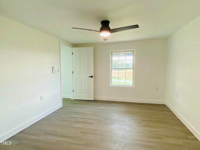 empty room with ceiling fan and light hardwood / wood-style floors