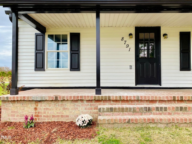 view of exterior entry with covered porch