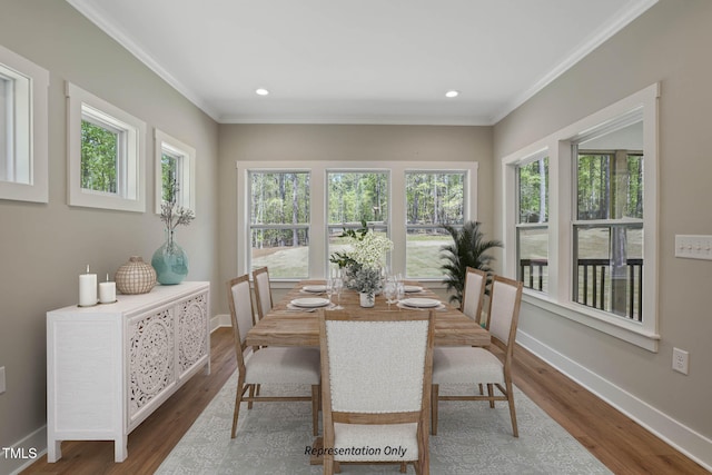 dining space with a wealth of natural light, dark wood-type flooring, and crown molding