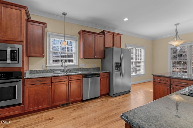 kitchen with crown molding, sink, hanging light fixtures, and appliances with stainless steel finishes