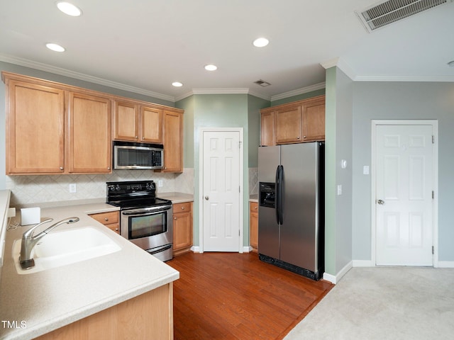 kitchen featuring sink, stainless steel appliances, light hardwood / wood-style flooring, backsplash, and ornamental molding