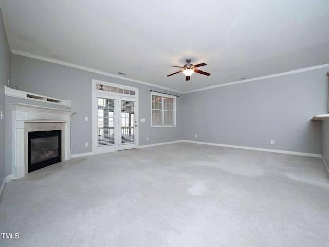 unfurnished living room featuring a high end fireplace, light colored carpet, ceiling fan, and crown molding