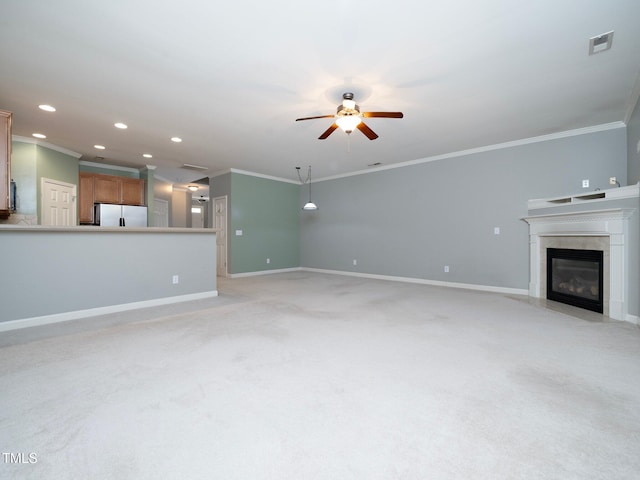 unfurnished living room featuring light colored carpet, ceiling fan, and ornamental molding