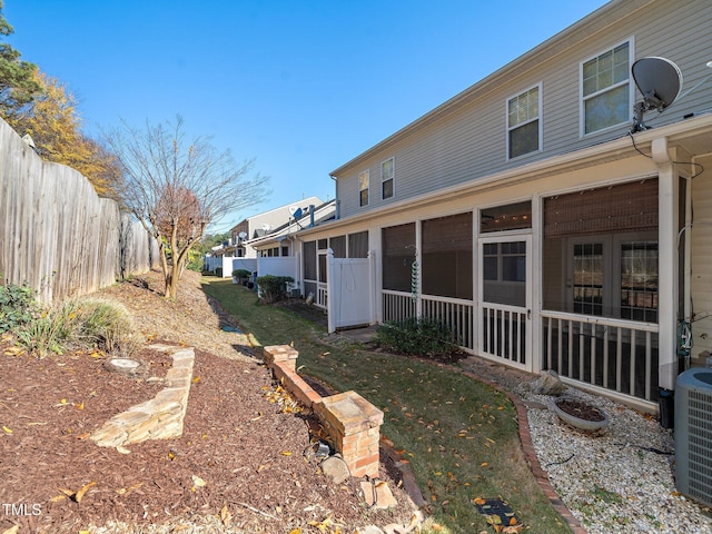 view of yard featuring a sunroom and central AC