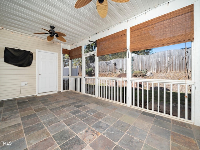 unfurnished sunroom with rail lighting