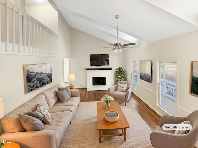 living room featuring hardwood / wood-style flooring, ceiling fan, and vaulted ceiling