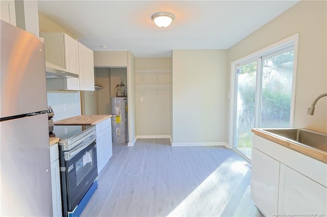 kitchen with white cabinetry, stainless steel appliances, light hardwood / wood-style flooring, exhaust hood, and gas water heater