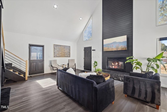 living room featuring high vaulted ceiling, a large fireplace, and dark hardwood / wood-style floors