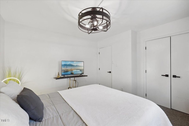 carpeted bedroom featuring a closet and a notable chandelier